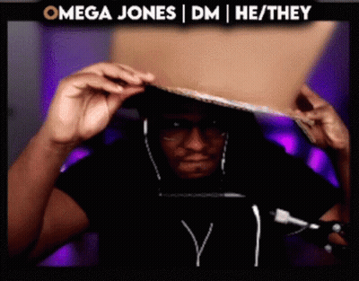 Man Wearing Headphones Holding Cardboard in Front of Omega Sign