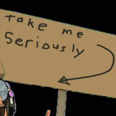 Man Wearing Headphones Holding Take Me Seriously Sign GIF