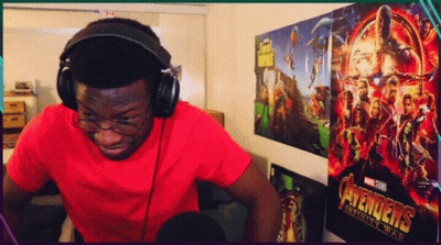 Man Wearing Headphones In Front Of Avengers Infinity War Poster GIF