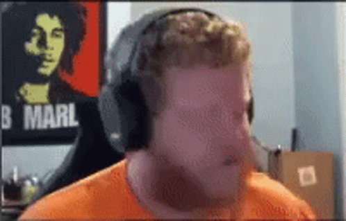 Man Wearing Headphones in Front of Bob Marley Poster