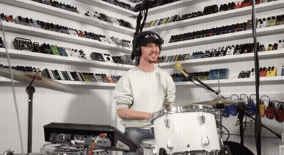 Man Wearing Headphones Playing Drum Set GIF