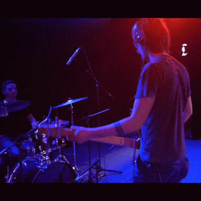 Man Wearing Headphones Playing Guitar On Stage GIF