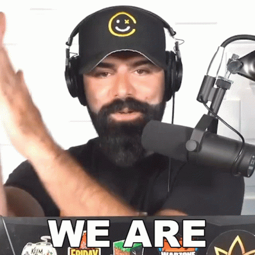 Man Wearing Headphones Stands In Front Of Microphone Says We Are GIF