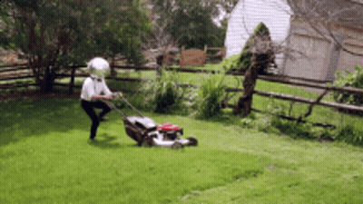 Man Wearing Helmet Mowing Lawn GIF