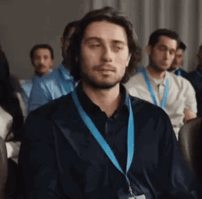 Man Wearing Lanyard Sitting In Room GIF