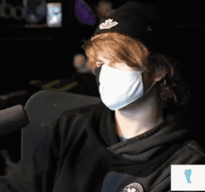 Man Wearing Mask And Hat Sitting At Microphone GIF