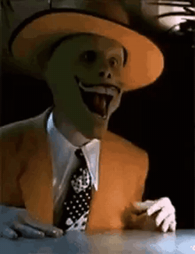 Man Wearing Mask And Hat Sitting With Tongue Out GIF