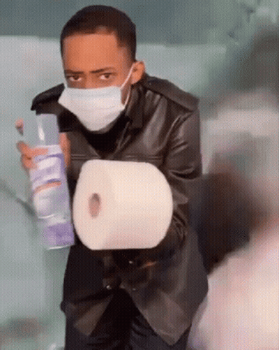 Man Wearing Mask Holding Toilet Paper And Spray GIF