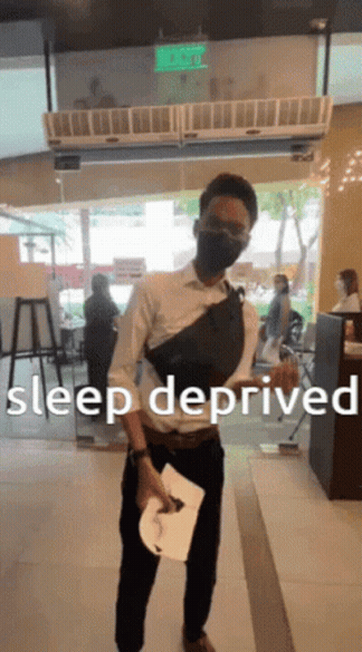 Man Wearing Mask Holds Paper In Front Of Sleep Deprived Sign GIF