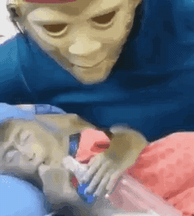 Man Wearing Mask Laying Next To Baby GIF