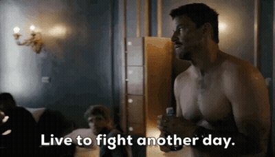 Man Wearing Mask Talking To Another Man In Dark Room GIF