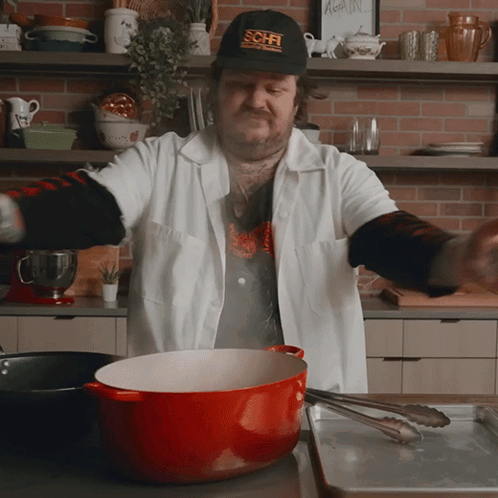 Man Wearing SciFi Hat Cooking In Kitchen GIF