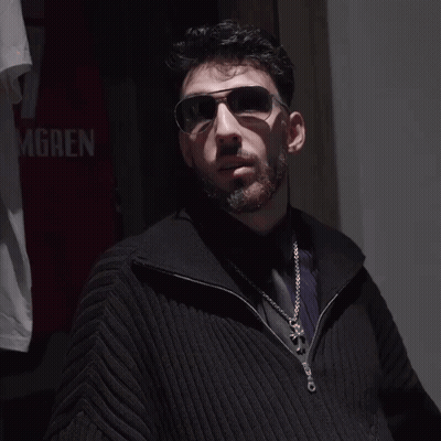 Man Wearing Sunglasses In Front Of Gren Shirt GIF