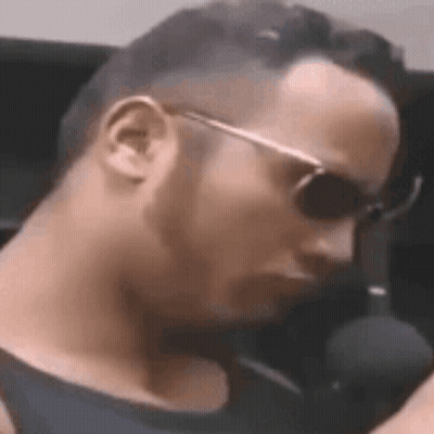 Man Wearing Sunglasses Sitting At Microphone GIF