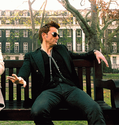 Man Wearing Sunglasses Sitting On Park Bench GIF