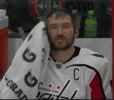 Man Wiping Face with Towel in Capitals Jersey