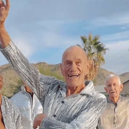Man With Arm In Air Surrounded By Three People GIF