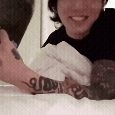 Man With Arm Tattoo Laying In Bed With Woman GIF