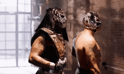 Man With Arm Tattoo Next To Masked Man GIF