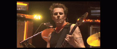 Man With Arm Tattoo Playing Guitar At Microphone GIF