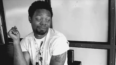 Man With Arm Tattoo Sitting Hands Folded GIF
