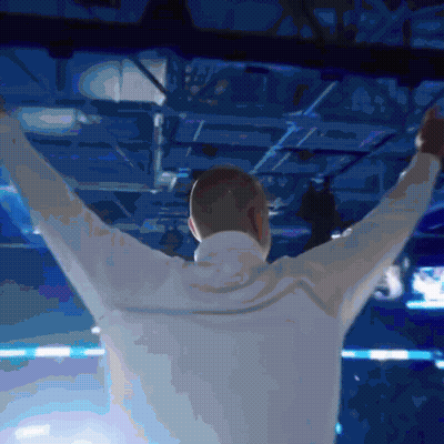 Man With Arms Outstretched In Blue Room GIF