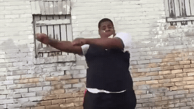 Man With Arms Outstretched In Front Of Brick Wall GIF