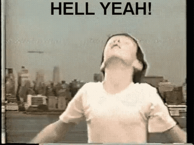 Man With Arms Outstretched In Front Of City Saying Hell Yeah GIF