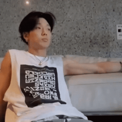 Man With Arms Outstretched On Couch In White Tank Top GIF