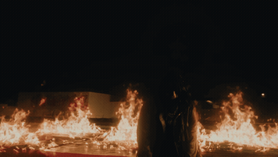 Man With Back Tattoo Beside Coffin With Flowers GIF