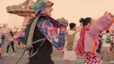Man With Backpack Dancing At Amusement Park GIF