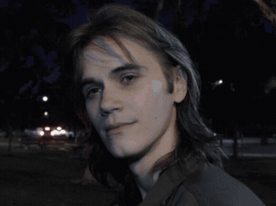 Man With Backpack In Front Of Brick Wall GIF