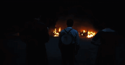 Man With Backpack In Front Of Fire GIF