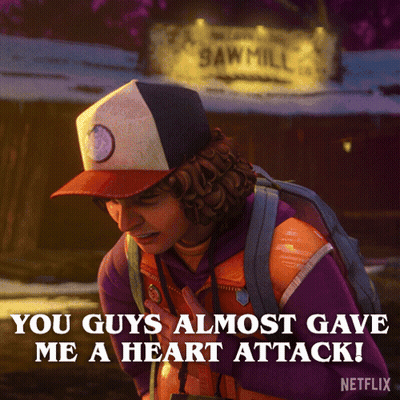 Man With Backpack In Front Of Sawmill Sign GIF