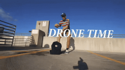 Man With Backpack In Parking Lot Saying Drone Time GIF