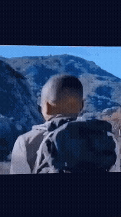 Man With Backpack Standing In Front Of Mountain GIF