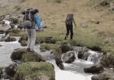 Man With Backpack Walking Across River GIF