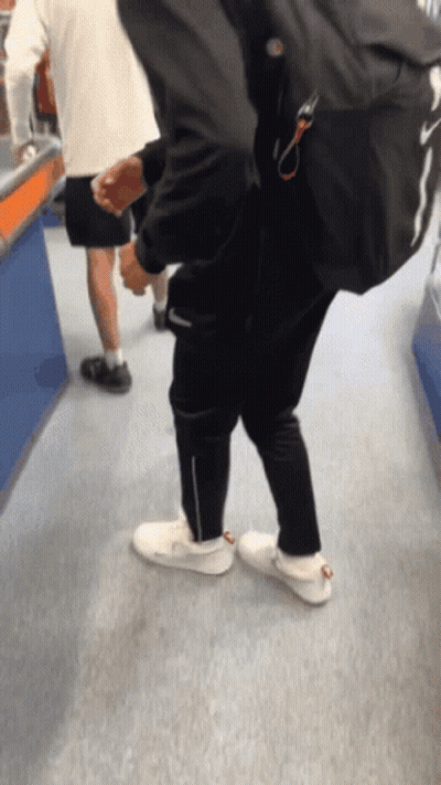 Man With Backpack Walking Down Carpeted Hallway GIF