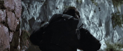 Man With Backpack Walking Up Rocky Hill GIF