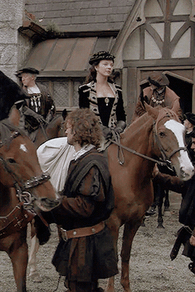 Man With Bag Standing Next To Woman Riding Horse GIF