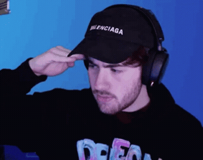 Man With Balenciaga Hat And Headphones Looks At Camera GIF