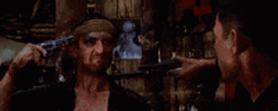 Man With Bandana Pointing Gun At Another Man GIF