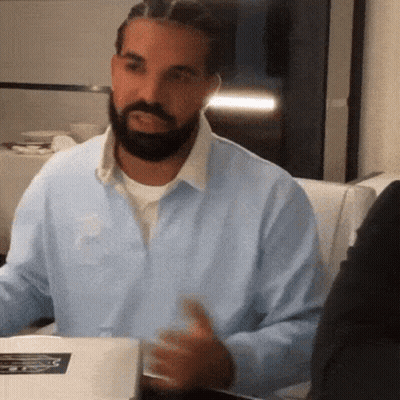 Man With Beard And Braids Sitting At Table GIF