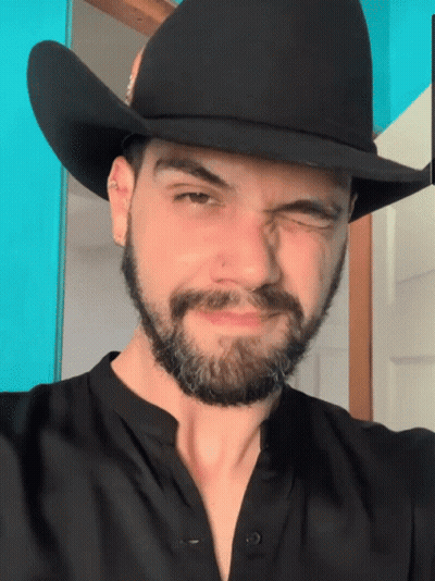Man With Beard And Cowboy Hat Winks GIF