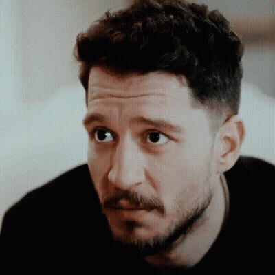 Man With Beard And Curly Hair Looking Serious GIF