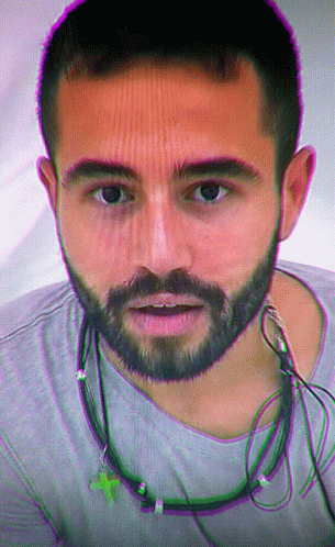 Man With Beard And Ear Buds Looking At Camera GIF