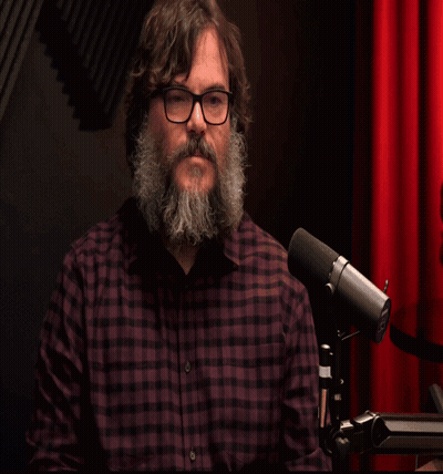 Man With Beard And Glasses At Microphone Saying Shalom GIF