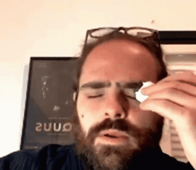 Man With Beard And Glasses Wipes Eye With Napkin GIF