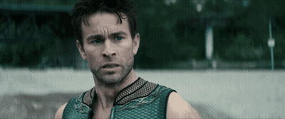 Man With Beard And Green Tank Top Looks At Camera GIF