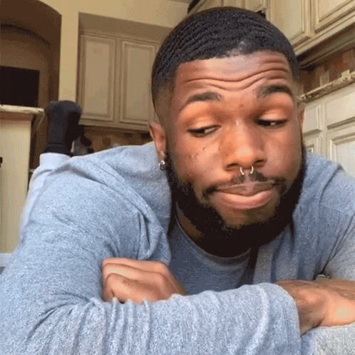 Man With Beard And Nose Ring Lying Down Making Face GIF